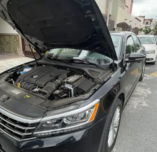 Sedán Volkswagen con el cofre abierto durante la instalación del ahorrador