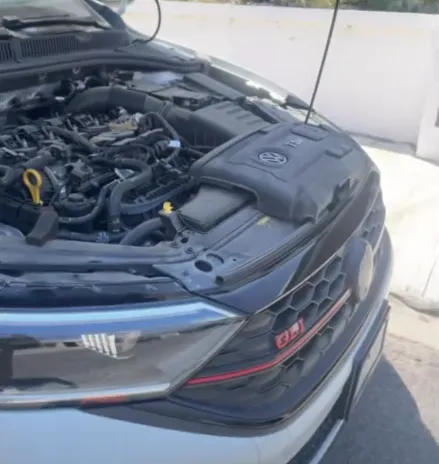Volkswagen GLI con el cofre abierto durante la instalación del ahorrador